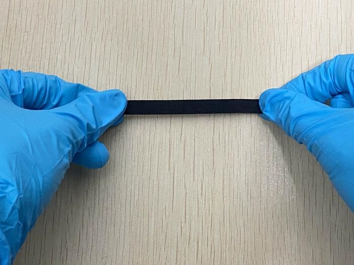 Image: The smart fabric being stretched to demonstrate its mechanical robustness (Photo courtesy of University of Waterloo)